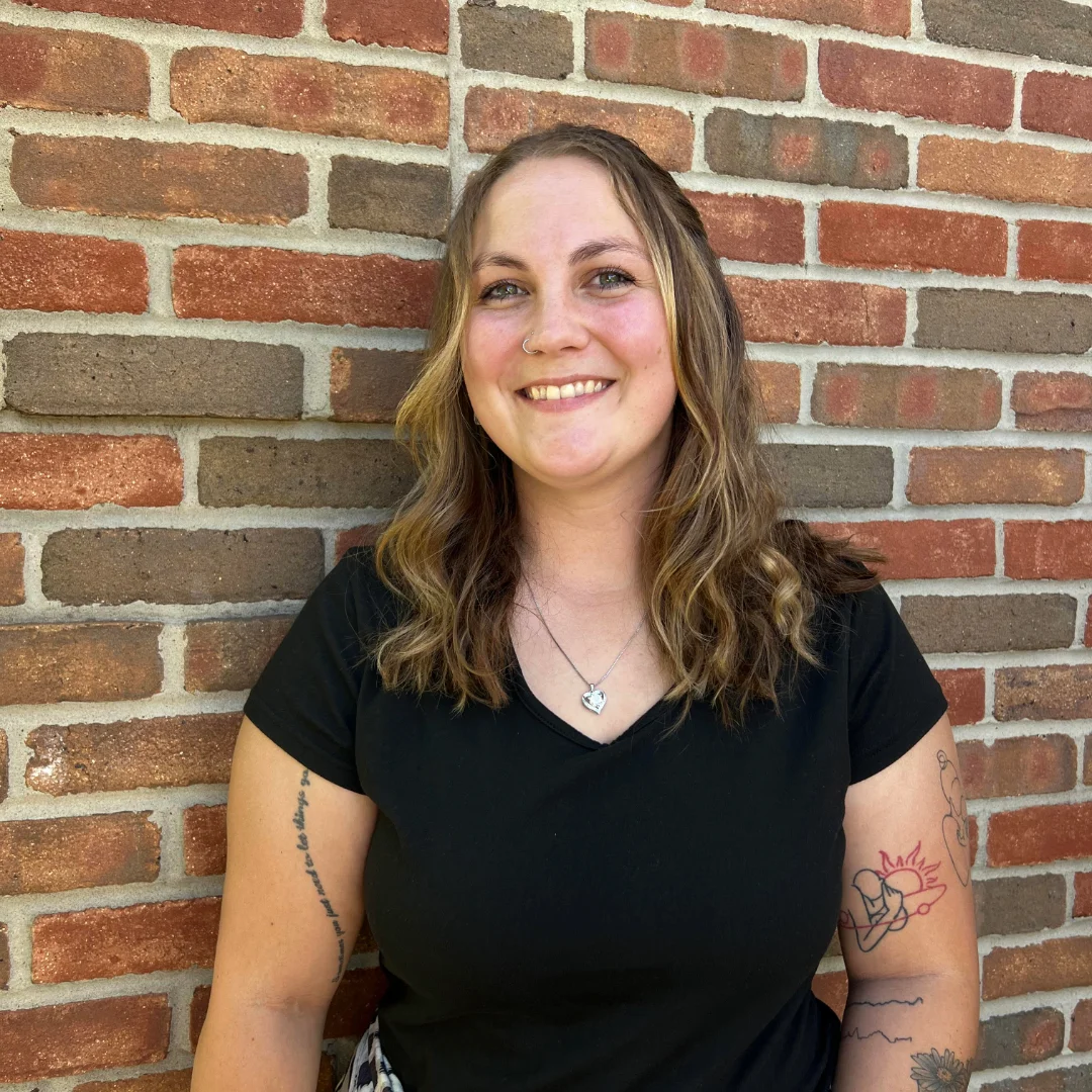 Danielle Barron headshot with brick background