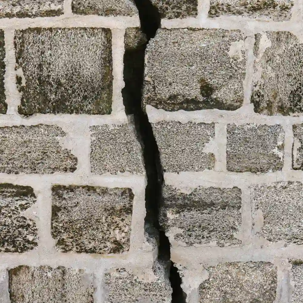 square-cropped close-up photo of a large crack running vertically through a foundation of light bricks (featured image: "Under Pressure: Practical Tools for Managing Stress & Finding Peace" mental health workshop)